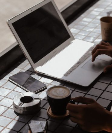 Modern workspace with laptop, coffee, and smartphone, perfect for remote work.